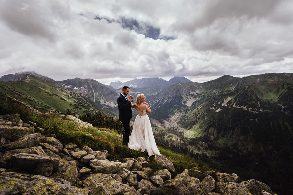 Sesja ślubna na Kasprowym Wierchu; Para Młoda trzymająca się za rękę.